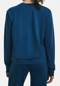 Sweatshirt bleu à manches longues, col rond et ourlet côtelé. Texture lisse et design ajusté, avec des détails de couture minimaux.