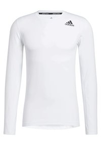 Vit långärmad träningsskjorta gjord av ett slätt, lätt tyg. Har en svart Adidas-logotyp på den övre vänstra sidan och en rund halsringning.