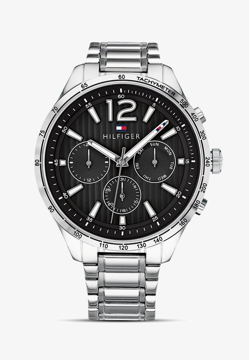 Sølv rustfrit stål ur med en sort tekstureret urskive, store tal, tre underlæggere og en tachymeter. Har et metal kædebånd.