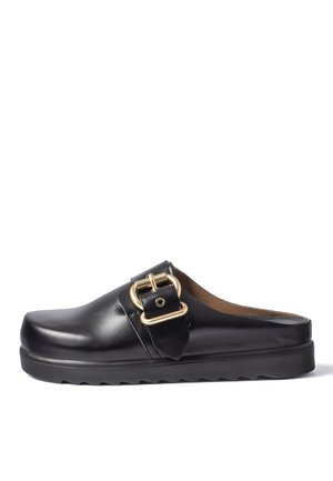 Sabot en cuir noir à enfiler avec semelle épaisse et large bride avec boucle dorée sur le dessus, présenté sur fond blanc.