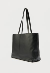 Černá kožená taška typu tote s hladkou texturou, svislým švem a dvěma prodlouženými uchy. Jednoduchý obdélníkový design.