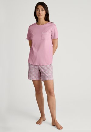 Rosa Baumwoll-T-Shirt mit kurzen Ärmeln und aufgesetzter Tasche, kombiniert mit gemusterten Shorts in Rosa und Weiß. Einfaches Design, lässige Passform.