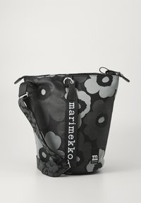Black and grey floral-patterned bucket bag made of durable fabric, featuring a zip closure, adjustable strap, and logo accents.