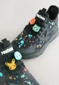 Sorte sneakers med et sprøjtmalet design, der har gummi-accenter af Pokémon-figurer og en overdel i mesh-stof. Snørebåndene er elastiske for nem påtagning.