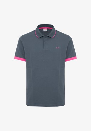 Polo gris oscuro con ribete rosa en el cuello y los bordes de las mangas, tapeta de dos botones y pequeño logo geométrico rosa en el pecho izquierdo.