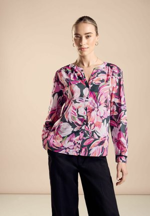 Blumenbluse in Rosa, Lila und Weiß auf dunklem Hintergrund. Verfügt über einen V-Ausschnitt, Knopfverschluss und lange Ärmel mit gerafften Akzenten.
