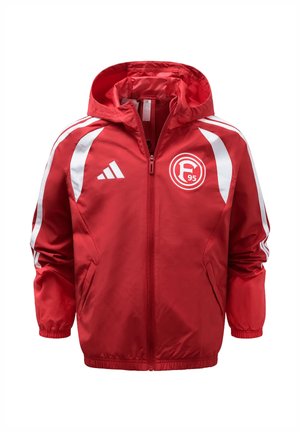 Czerwona sportowa kurtka z kapturem i zamkiem błyskawicznym, z białym logo Adidas na prawej piersi oraz emblematem klubu Fortuna Düsseldorf na lewej piersi.