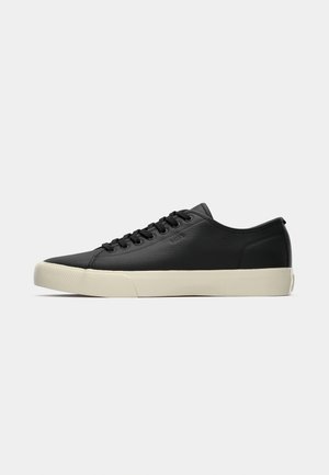 Lage zwarte leren sneaker met zwarte veters en off-white rubberen zool, zijaanzicht met subtiele "BOSS" branding.