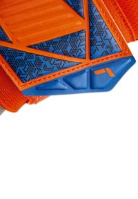 Le scarpe sportive arancioni e blu presentano una suola in gomma testurizzata con motivi geometrici e un design della fascia accentuato.