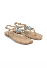 Sandali in suede beige con suola piatta, caratterizzati da un design decorativo di luna e stelle realizzato con rhinestone blu e dettagli dorati.