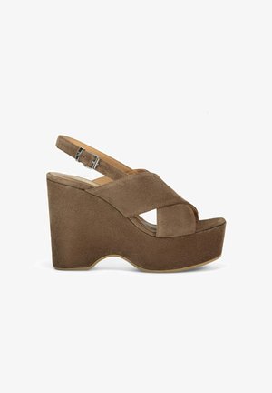 Sandales compensées en suède marron avec des sangles croisées, bout ouvert, une sangle de cheville réglable et une semelle épaisse.