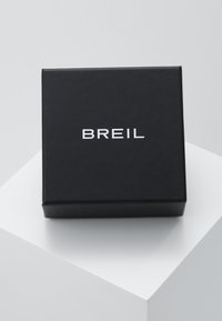 Sort gaveæske med mat overflade, der har et præget hvidt "BREIL" logo på forsiden, kvadratisk form og skarpe hjørner.