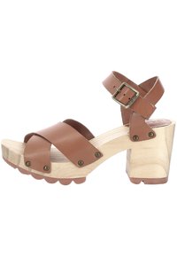 Sandal con tacco in pelle marrone con cinturini incrociati, tacco a blocco in legno e fibbia in metallo. Suola testurizzata con bordi scallop.