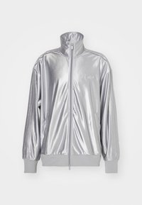 Stříbrná bunda na zip z lesklého materiálu; má vysoký límec, žebrované manžety a boční kapsy s logem na hrudi.