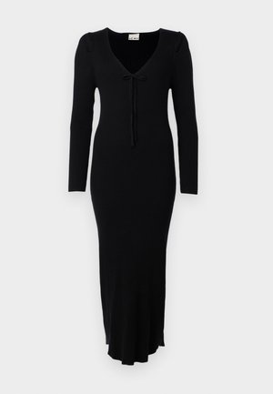 Fekete bordás kötött ruha hosszú ujjakkal, V-kivágással és elöl masni részlettel. Testhezálló fazonú és bővülő alsó szegéllyel rendelkezik.