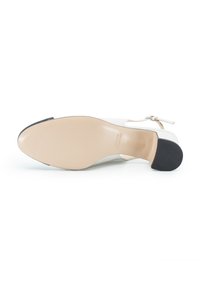 Scarpa con tacco bianca con tomaia in pelle liscia, punta chiusa e una sola fascia. Presenta una soletta beige e una suola in gomma nera.