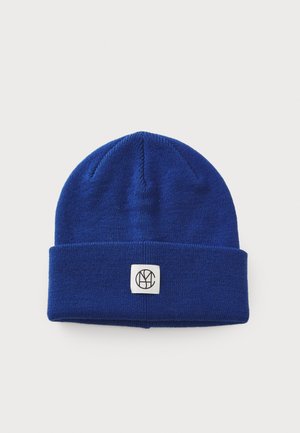 Blue knit beanie with a folded cuff, featuring a square tag with a black logo. Soft texture and classic design for warmth.
