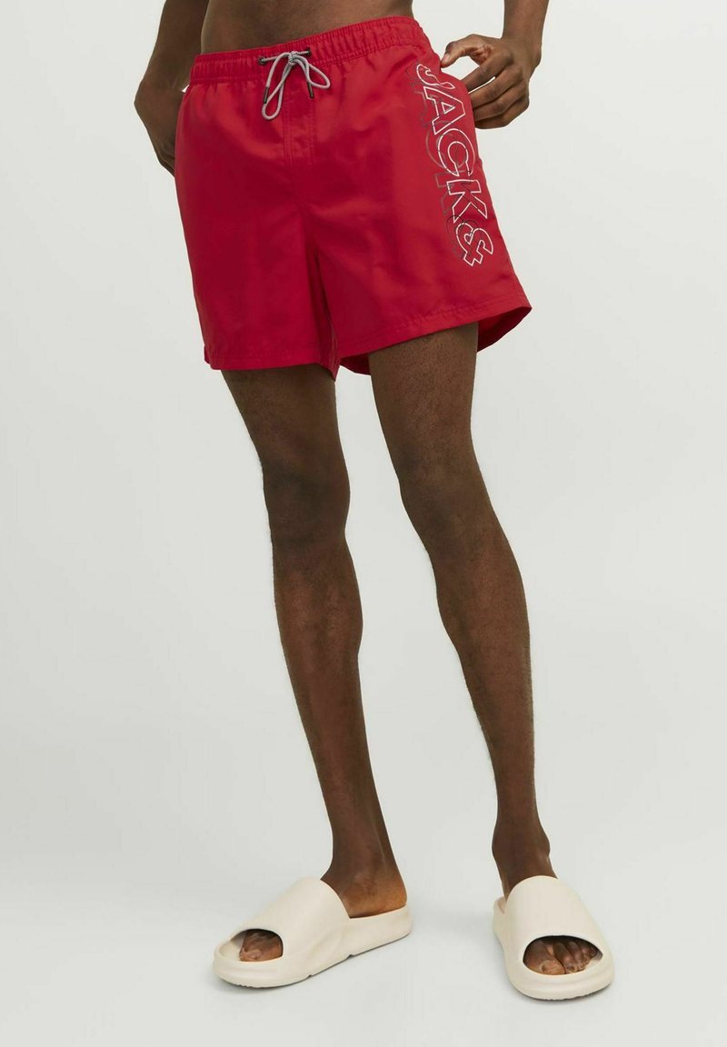 Bañadores rojos con cordón gris, con "JACKS" impreso en el lateral. Fabricados en material ligero con una textura suave.
