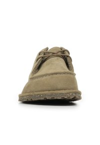 Chaussure en daim marron avec un bout arrondi, des accents cousus et des lacets marron. Semelle texturée et flexible avec des motifs de grip. Design simple et discret.