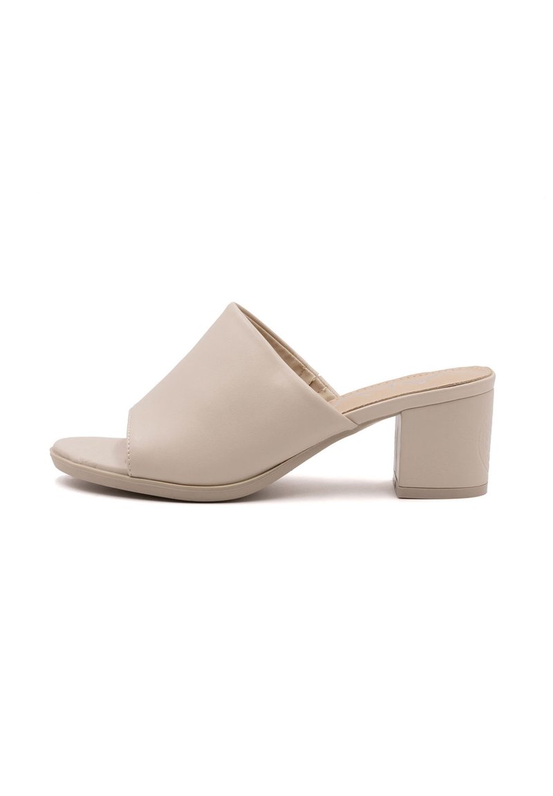 Mule beige con tacco a blocco aperte, con tomaia in pelle liscia, dotate di una larga fascia frontale e un tacco quadrato robusto.