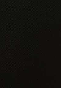 Tessuto nero con texture intrecciata diagonale. La superficie appare liscia ma leggermente rigata, offrendo una sottile profondità e un motivo.
