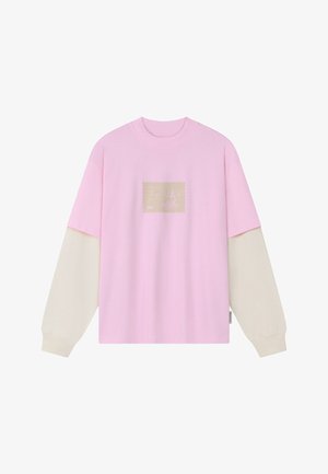 Langermet rosa genser med kremfargede ermer og et beige rektangulært grafisk motiv i midten med subtile arkitektoniske design.