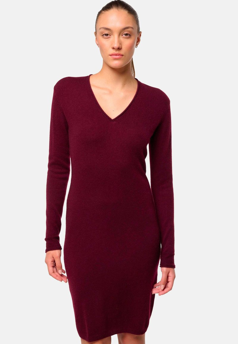 Robe en tricot bordeaux à manches longues avec décolleté en V, au design ajusté, arrivant au milieu de la cuisse, fabriquée en tissu doux et lisse.