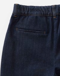 Un pantalon en denim bleu foncé avec une taille élastique, une poche arrière sans accessoires visibles et des détails de couture orange contrastants.