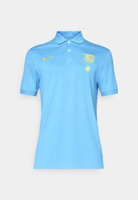 Svetlo modra polo majica s ovratnikom, kratkimi rokavi, Nike logotipom in Barceloninim grbom v rumeni barvi. Narejena iz gladkega blaga.