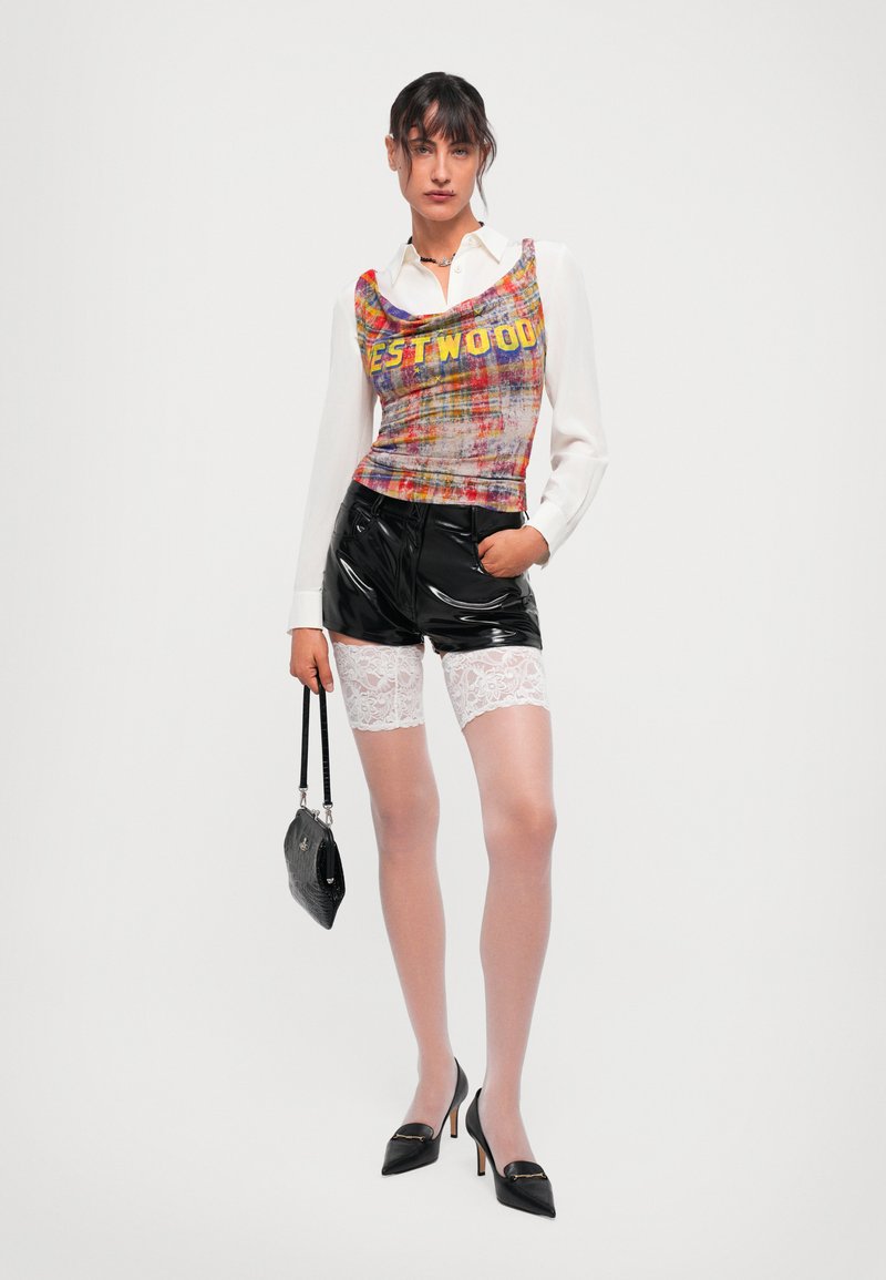 Multicolor, textured tank top with 'WESTWOOD' text, paired with shiny black shorts, lace-trimmed white tights, and black heels. Small black bag.