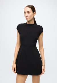 Black dress made of smooth fabric, featuring a high neck, short sleeves, fitted bodice, and flared skirt with seam details.