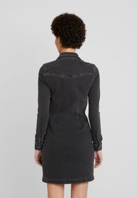 Musta farkkukjoloo pitkillä hihoilla, muotoiltu malli ja kaulus. Varmistaa nappi hihansuut ja hienovaraiset ompelupinnat.