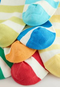 Calcetines con rayas de colores superpuestos, mostrando los dedos en tonos azul, rojo, naranja, amarillo, verde y azul verdoso sobre un fondo blanco.