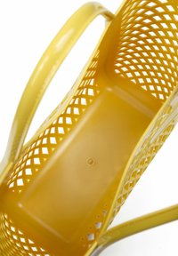 Gele plastic mand met open rasterontwerp, gebogen handvatten en rechthoekige basis. Glad oppervlak met een cirkelvormig detail op de basis.