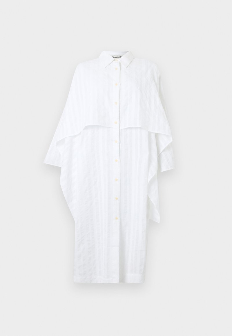 Robe-chemise blanche longue à boutons avec une couche ample semblable à une cape sur les épaules et des manches longues.