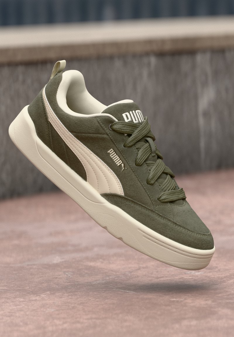 Olive green suede sneaker with beige accents and textured laces, featuring a thick white rubber sole and side Puma logo.