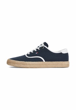 Marineblauer Canvas-Sneaker mit weißen Besätzen und Schnürsenkeln, gewebter beiger Sohle, niedrigem Design und kleinem Logo an der Seite.