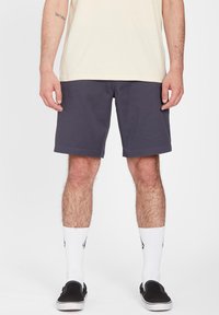 Dark grey shorts with a simple design, made from cotton blend fabric, paired with white crew socks and black slip-on shoes.