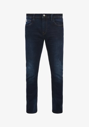 Jeans de mezclilla azul oscuro con un corte ajustado, que presentan un diseño de cinco bolsillos, un ligero desgastado cerca de los muslos y detalles de costura en contraste.