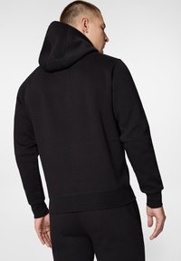 Czarna bluza z kapturem, wykonana z miękkiego materiału, z gładką fakturą, dopasowanymi mankietami i szczegółem w postaci kieszeni kangurzej.