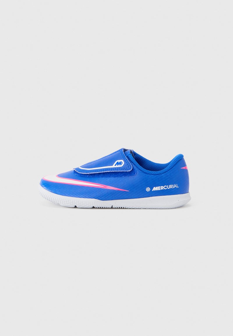 Zapatilla deportiva azul con parte superior sintética lisa, detalles en rosa y banda elástica. Cuenta con una suela de goma blanca con agarre texturizado.