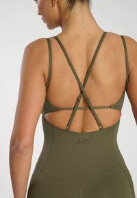 Olivgrön sportbodysuit med korsad bärdesign, som har en utskärning, slät textur och diskret logotyp på baksidan.