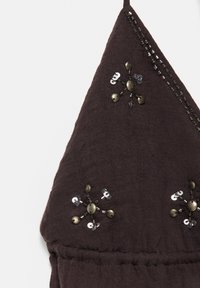 Tissu marron foncé avec bordure perlée noire et ornements floraux en perles métalliques et sequins formant un motif triangulaire.