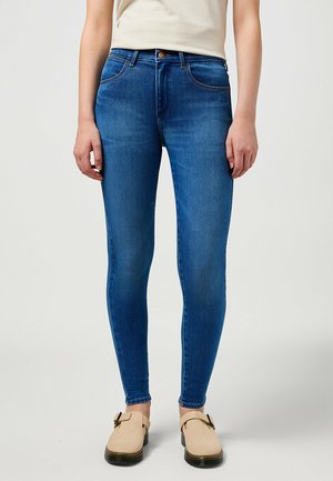 Jeans skinny blu in denim per donna con vita media, cinque tasche e una texture liscia. Presentano una chiusura con bottone e zip.