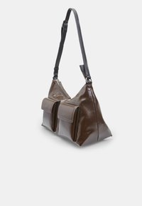 Borsa a mano lucida marrone con forma triangolare, due tasche frontali e tracolla nera staccabile. Chiusura con zip e finitura texturizzata.