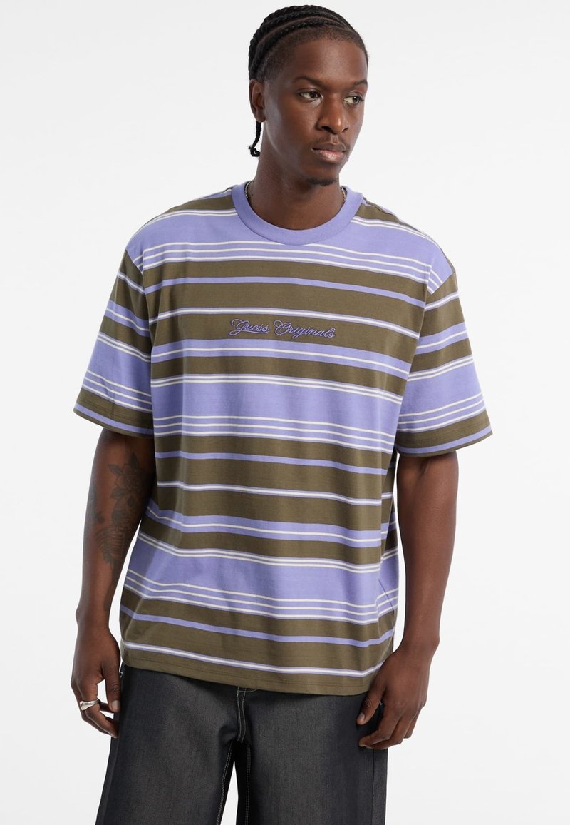 Gestreiftes T-Shirt in lila, olivgrün und weiß; lockere Passform mit kurzen Ärmeln und besticktem "Guess Originals"-Logo.
