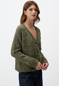 Olijfgroen cardigan, getextureerd breisel, V-hals, drie bruine knopen aan de voorkant, lange mouwen en een cropped zoom.