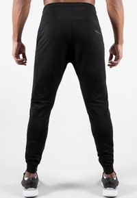 Pantaloni da jogging neri, con design affusolato, vita elasticizzata e tasca posteriore. Realizzati in materiale morbido ed elastico.