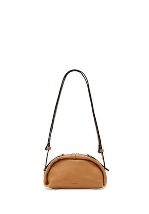 Miękka torebka z beżowej skóry w kształcie półksiężyca z czarnym regulowanym paskiem na ramię i srebrnym zamkiem błyskawicznym, minimalne oznaczenia marki na przodzie.