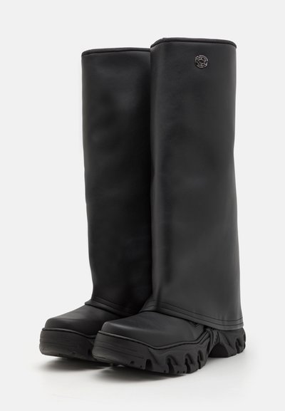 Botine negre până la genunchi, realizate din piele netedă. Talpă chunky din cauciuc cu profil pronunțat. Emblema subtilă pe partea superioară.